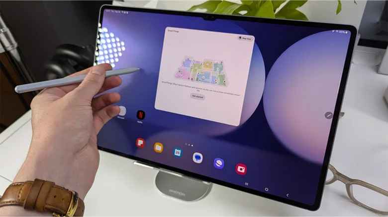 A person holding a stylus up to a Samsung tablet