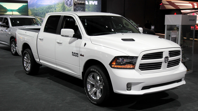 A white Dodge Ram 1500 is parked for a show