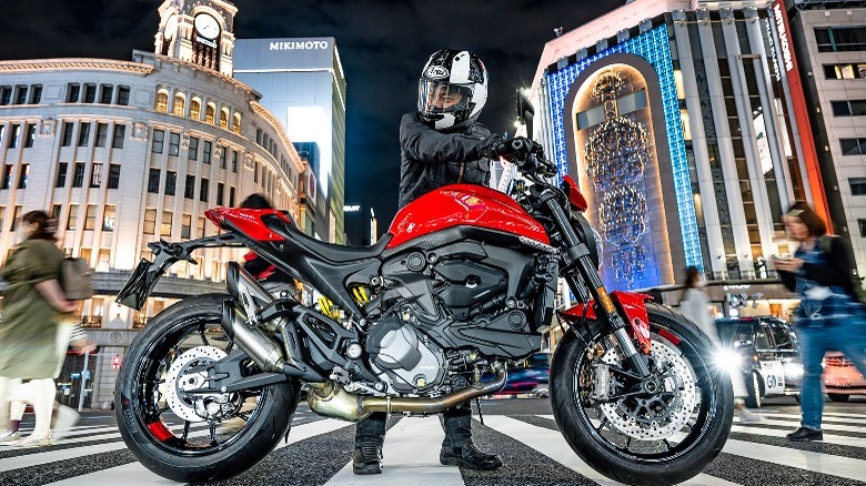 a rider holding a red Ducati Monster