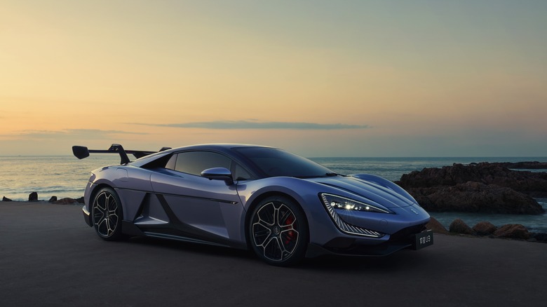 BYD Yangwang U9 electric hypercar front 3/4 view, parked near the sea on sunset