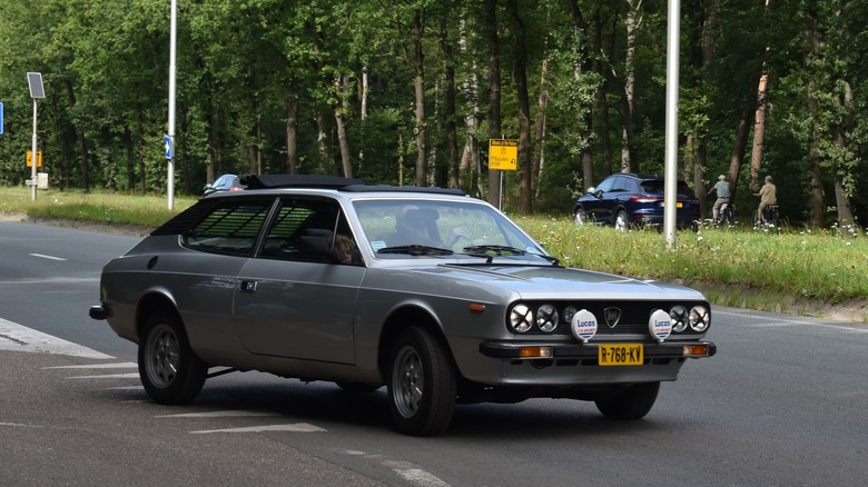 A Lancia Beta HPE in silver driving, front 3/4 view