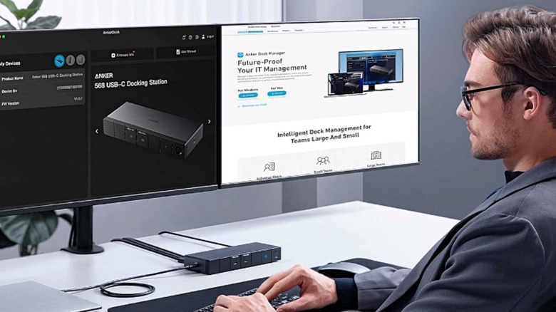 A man with multiple monitors connected to the Anker 568 USB-C Docking Station.