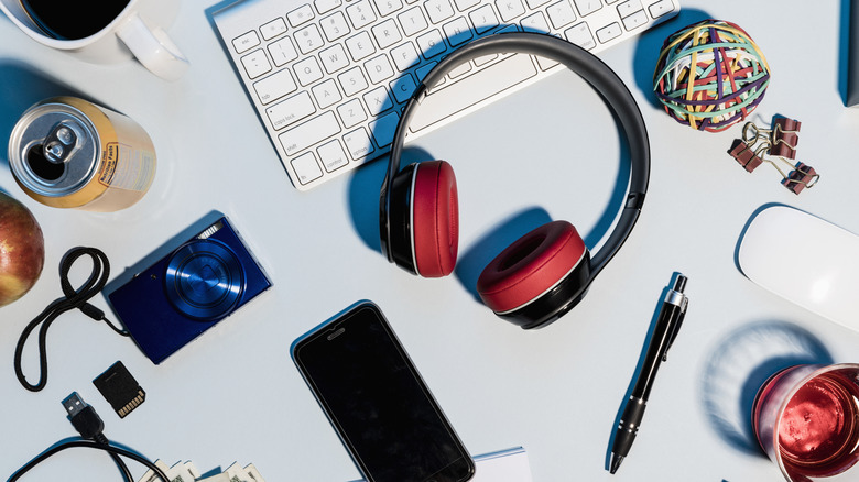 A bunch of gadgets laid out on a desk.