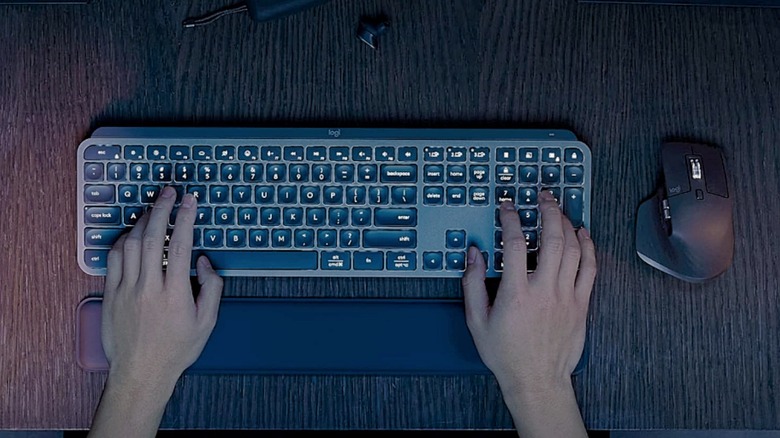 A pair of hands typing on the Logitech MX Keys.