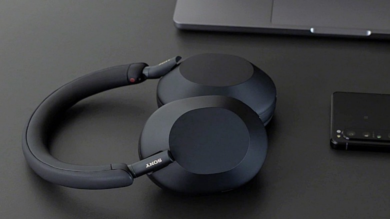 A set of Sony WH-1000XM5 headphones resting on a desk.