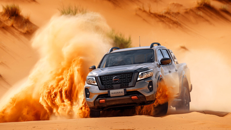 2024 Nissan Navara driving through a desert at speed