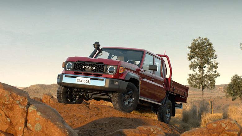 Red 2024 Toyota Land Cruiser 70 Pickup on a rocky terrain