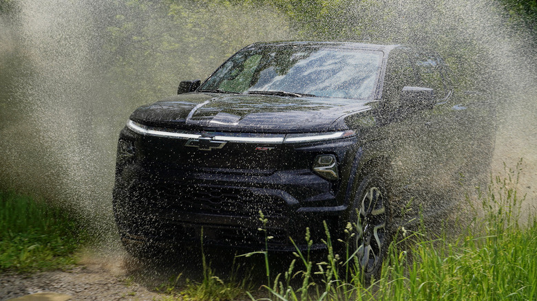 2024 Chevrolet Silverado EV RST First Edition driving through mud on an off-road trail