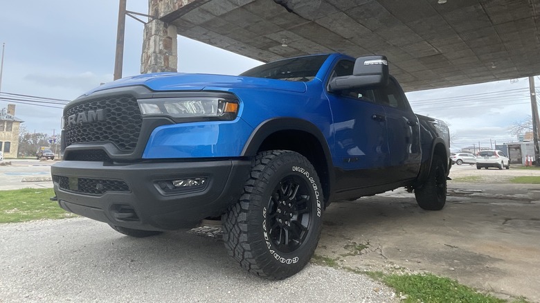 Blue 2024 Ram 1500 with all-terrain tires photographed from a lower angle