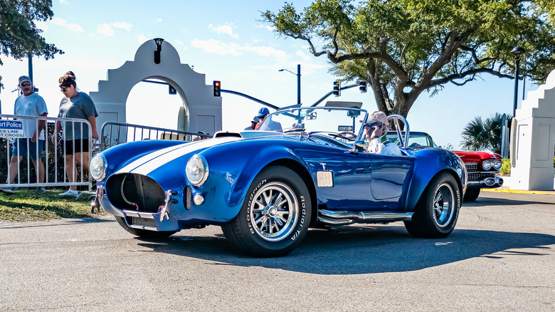 A blue Shelby Cobra on a town street