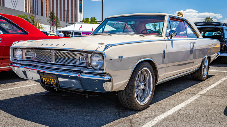 A white Dodge Dart in a parking lot