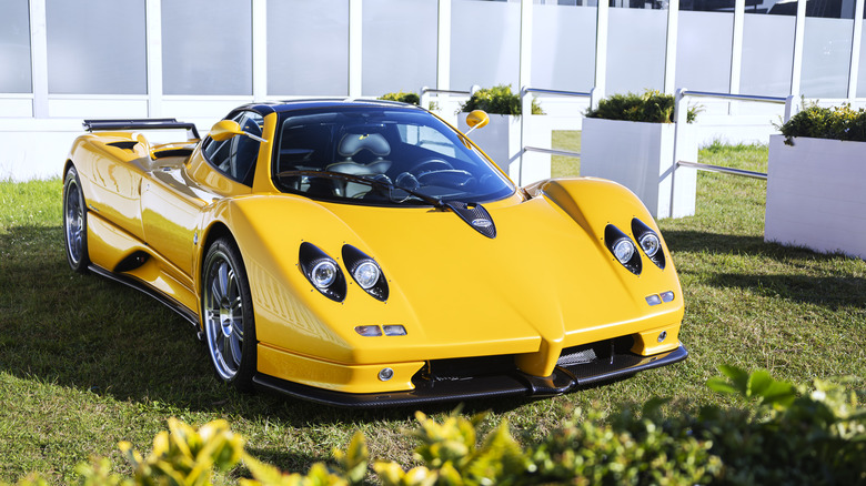 A yellow Pagani Zonda parked in some grass