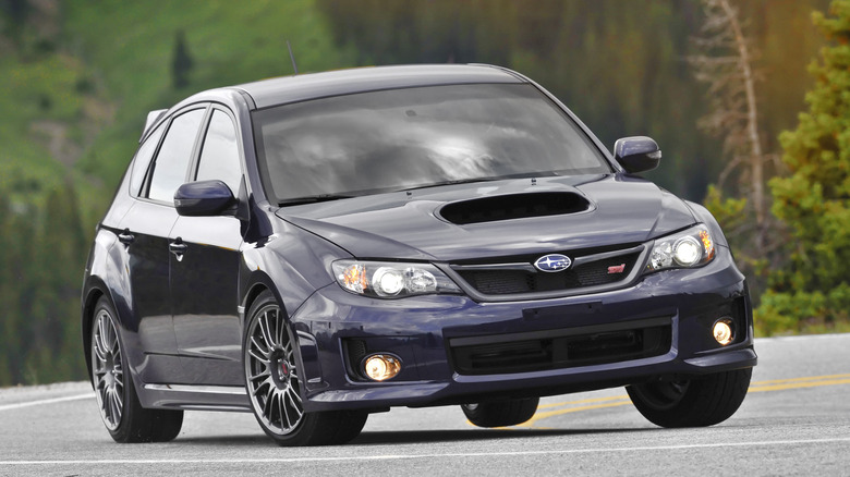 2008 Subaru Impreza WRX STI hatchback cornering at speed front 3/4 view