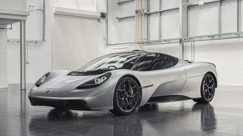 GMA T.50 hypercar front 3/4 view, parked in an empty warehouse