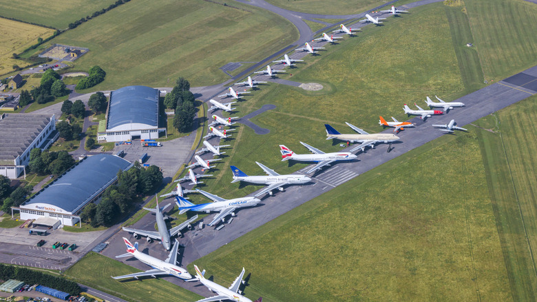 Airplanes parked on runway surrounded by grass