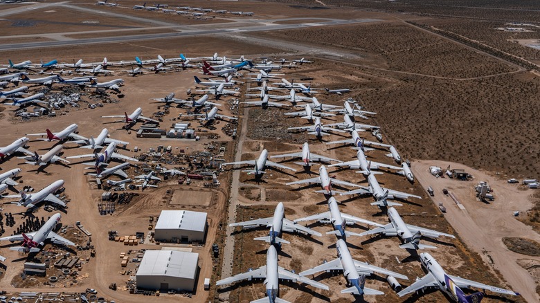 Small, medium and large airplanes parked on desert sand