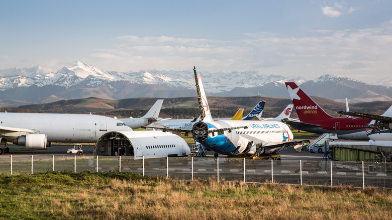 Big white airplanes parked with mountains in background