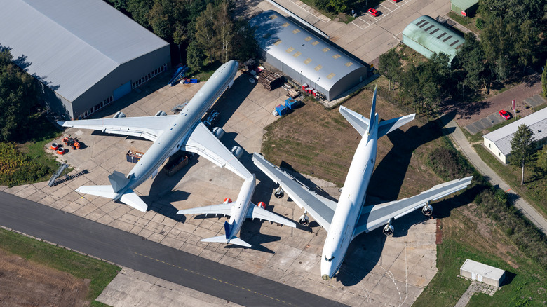 Two big and one small aircraft at maintenance facility