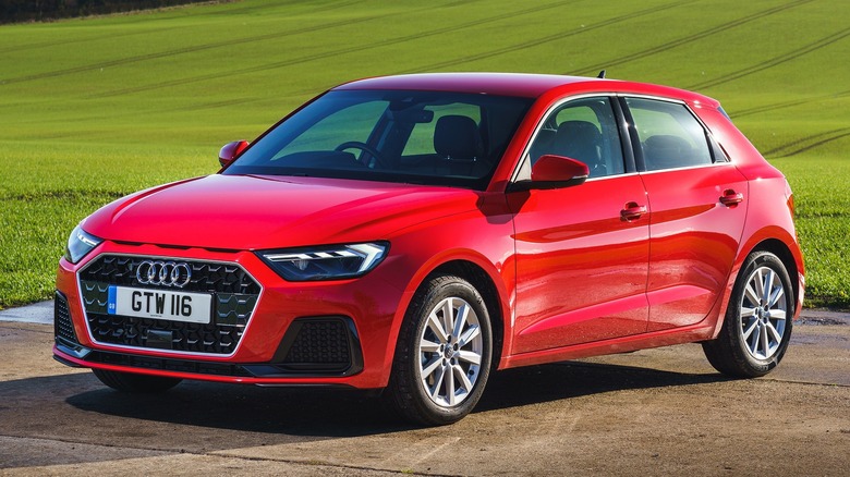 Red Audi A1 parked next to a green field