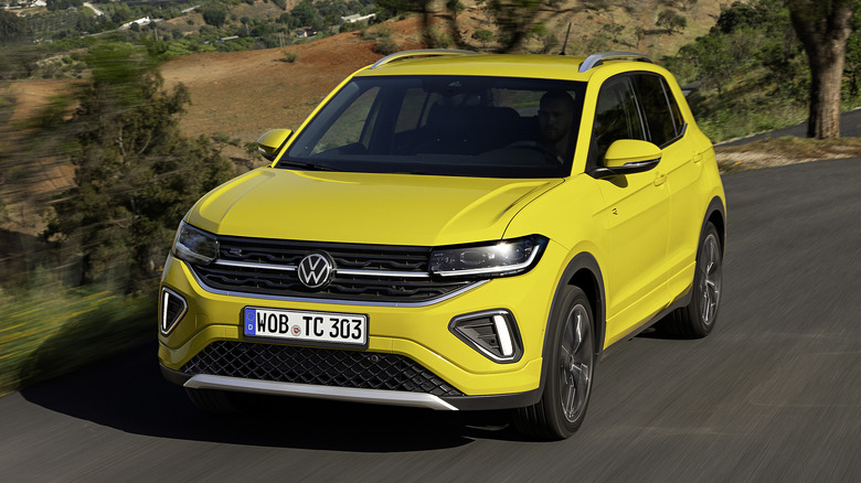 Yellow VW T-Cross cruising on mountainous road