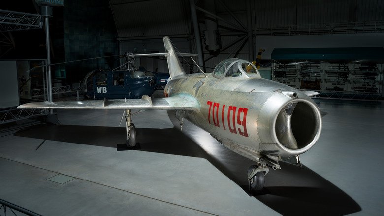 Silver MiG 15 parked in hangar