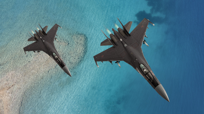 A pair of Su-27 fighter aircraft over water