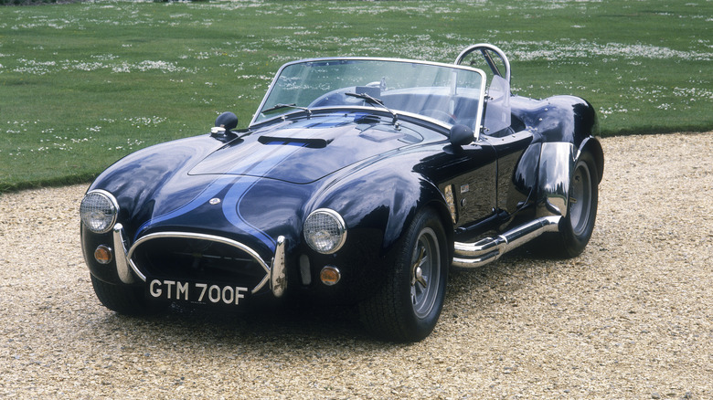 A blue Shebly Cobra sitting on a gravel driveway