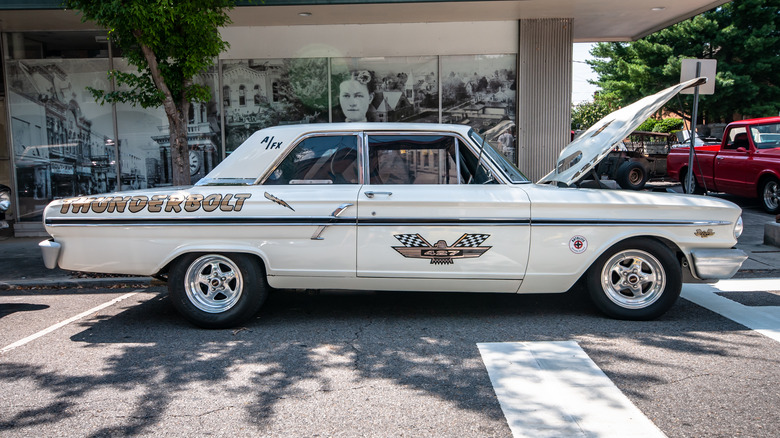 A white Ford Fairlane Thunderbolt parked on a city street