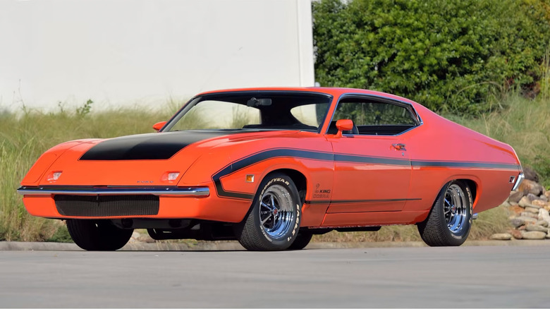 An orange-red Ford Torino King Cobra in a parking lot