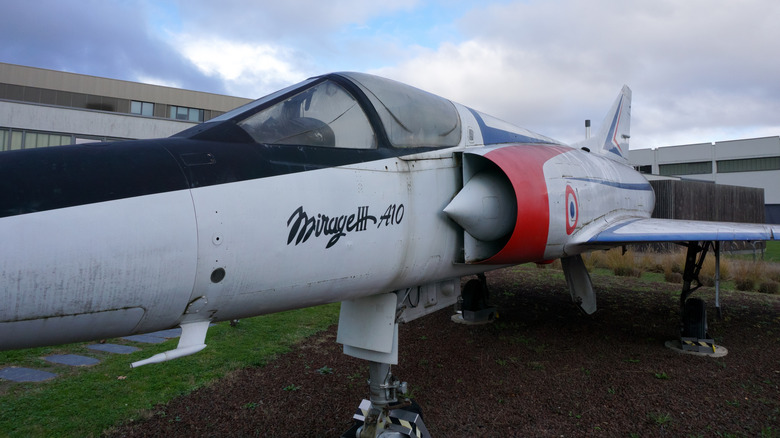 Mirage III aircraft parked in front of building.