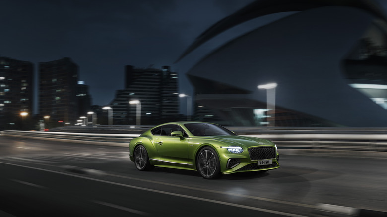 The new Bentley Continental GT Speed in green driving at night, front 3/4 view