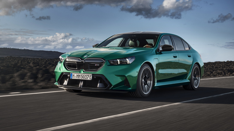 The G90 BMW M5 in green driving, front 3/4 view