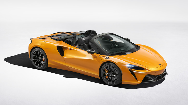 The McLaren Artura Spider in orange, front 3/4 view, roof down