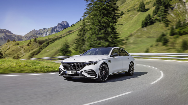 The Mercedes-AMG E53 Hybrid in white driving, front 3/4 view