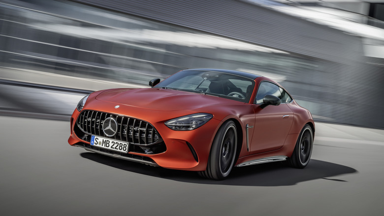 The Mercedes-AMG GT 63 E Performance in orange driving, front 3/4 view