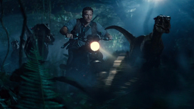 Owen Grady riding next to velociraptors