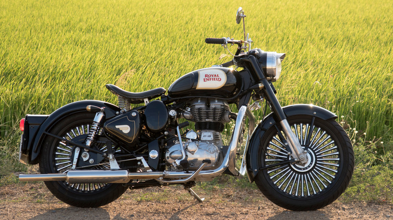 black and chrome Royal Enfield Classic 500 motorcycle parked in front of a field