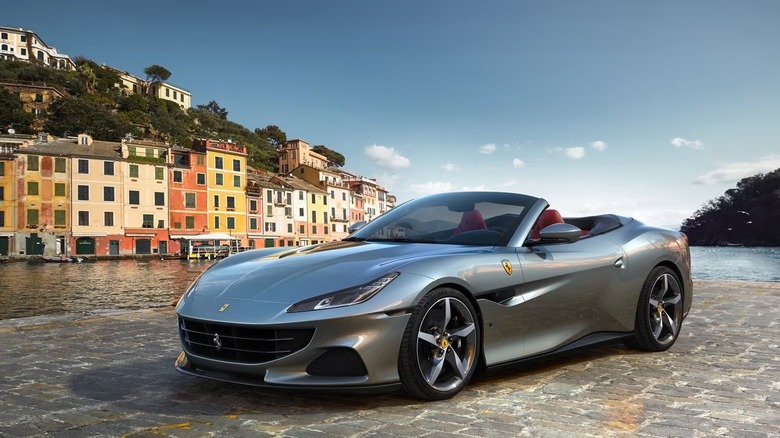 Grey metallic Ferrari Portofino M convertible parked on a port near the sea