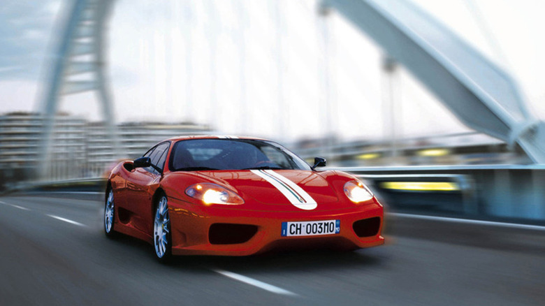 Red Ferrari 360 Challenge Stradale driving on a bridge