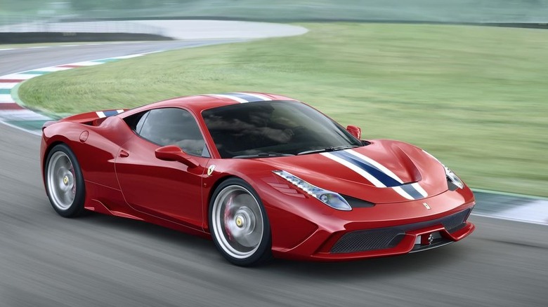 Red Ferrari 458 Speciale with a white/blue center stripe driving at speed, front view 3/4