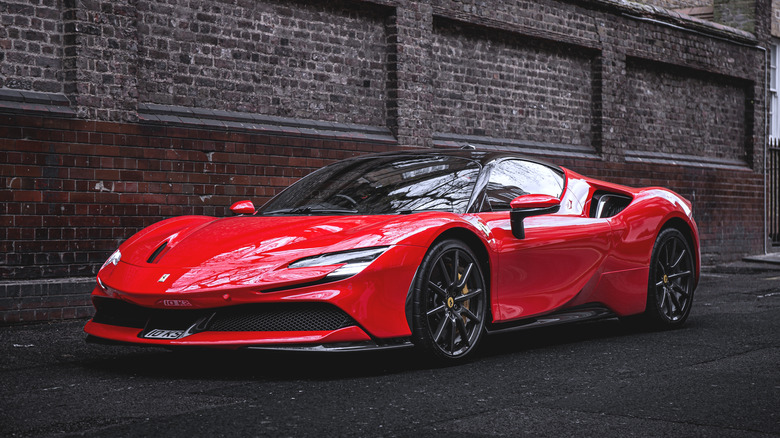 Red Ferrari SF90 parked on an empty street in London front 3/4 view