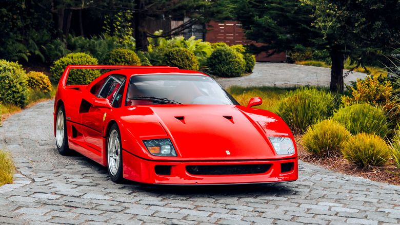 Red Ferrari F40 from the front with trees behind