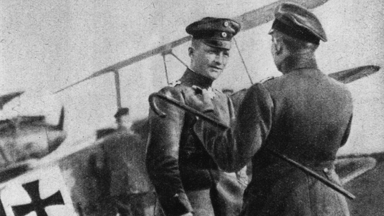 Manfred von Richthofen, aka The Red Baron, in front of his famous biplane