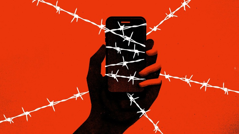 a smartphone entwined in barbed wire