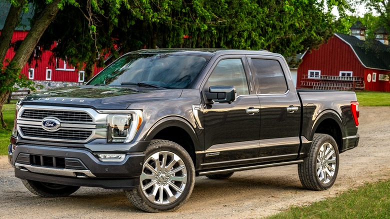 Black Ford F-150 with red barn in the background