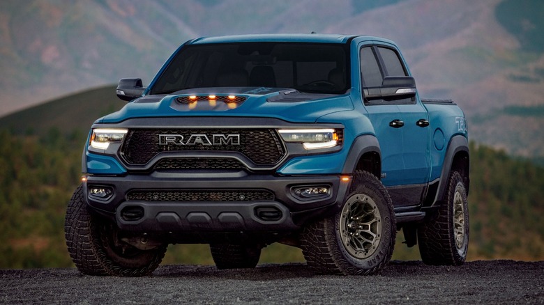 A teal Ram Pickup with a mountain in the background