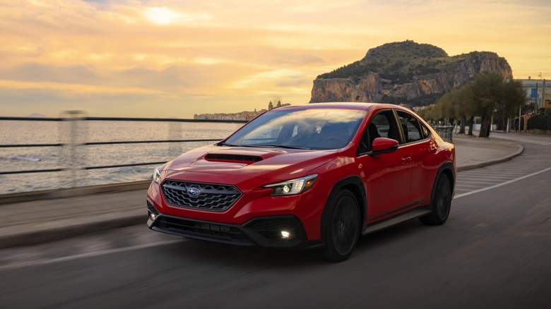 The 2024 Subaru WRX in red, driving, front 3/4 view