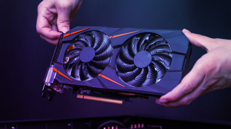 Hands holding a gaming graphics card