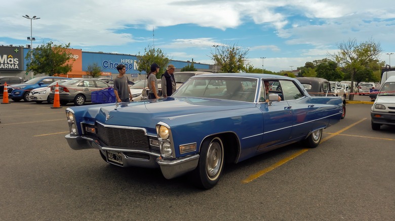 A blue, four door 1968 Cadillac in a parking lot