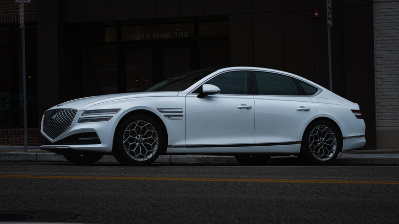 A white Genesis G80 sedan at dusk